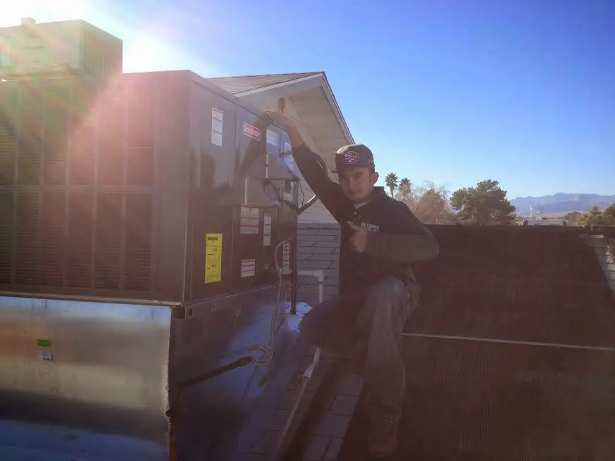 HVAC technician performing Air Duct Cleaning on a rooftop unit in Pine